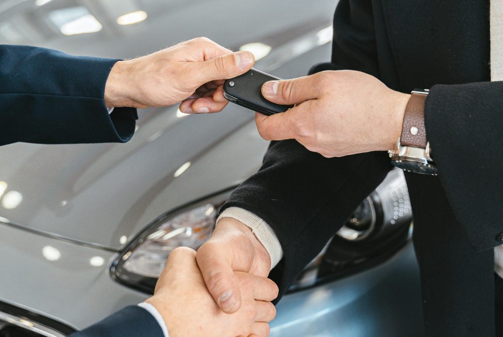 man handshaking and passing keys to the buyers