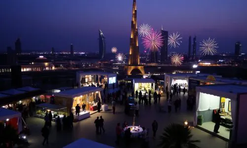 Dubai skyline at night with fireworks and outdoor job fair event.
